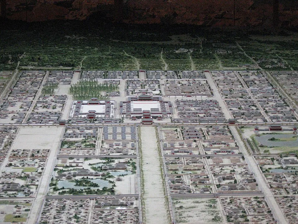 Maquette vue de haut : bâtiments à toits alignés, cours rectangulaires et larges axes perpendiculaires.
