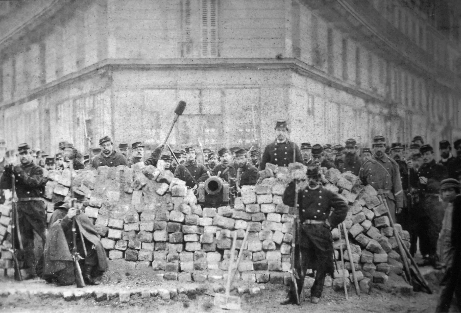 Photographie d’une barricade de pavés et de tonneaux au croisement des boulevards Voltaire et Richard-Lenoir pendant la Commune de Paris