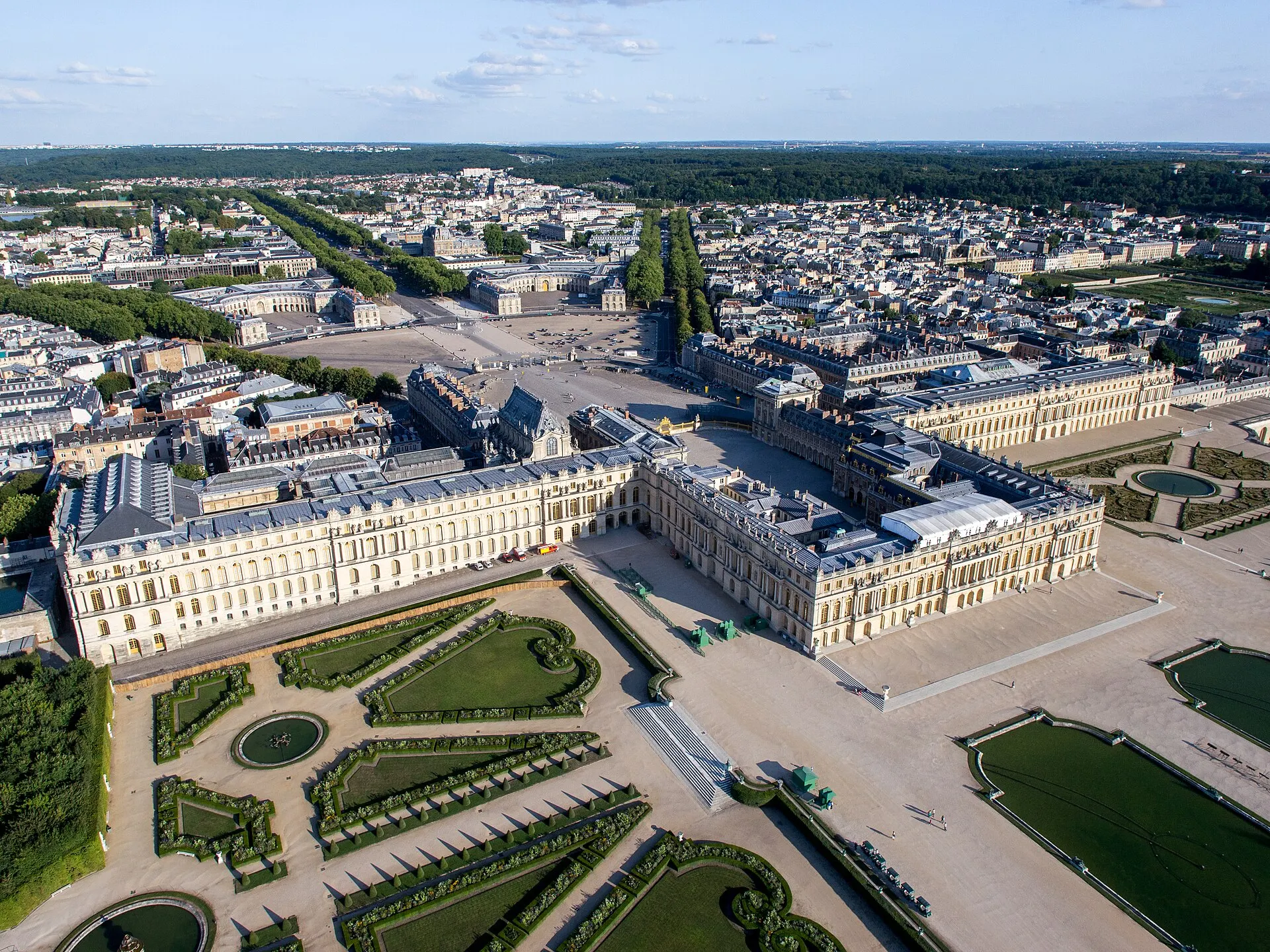Vue aérienne du château de Versailles, de ses cours, de ses jardins géométriques et de ses longues perspectives